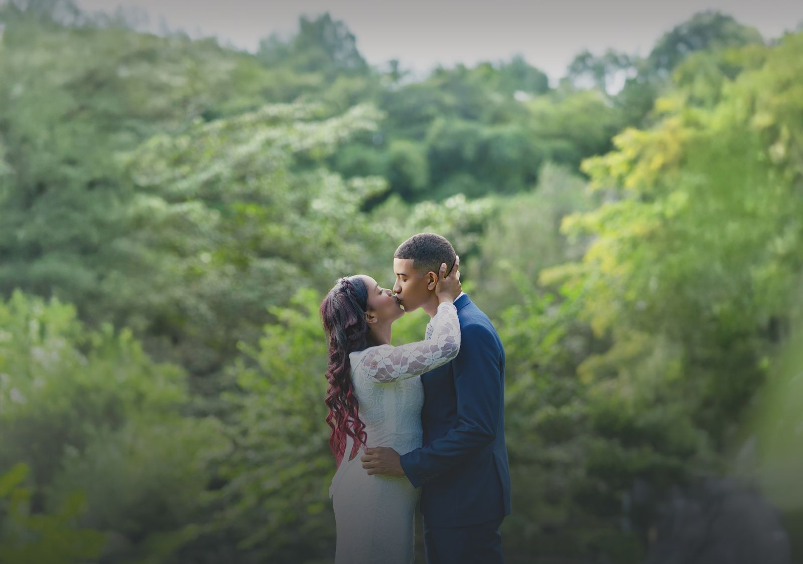 Novios besándose rodeados de vegetación